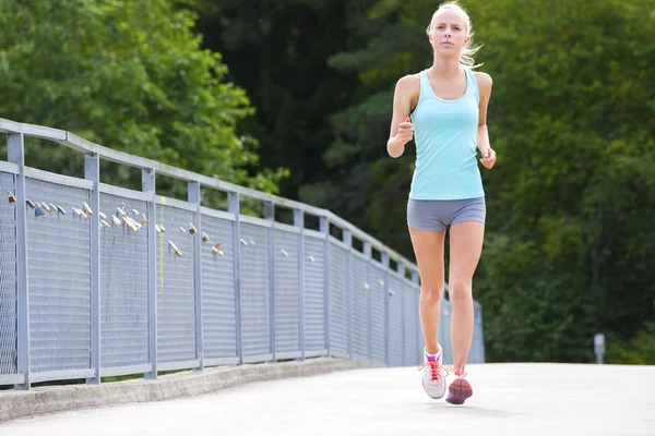 Woman runs outdoor on a bridge as stamina training — Stock Photo, Image