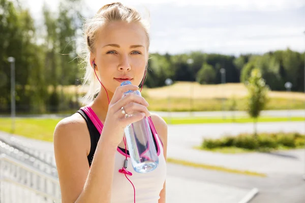 Γυναίκα πίνει νερό μετά το τρέξιμο στην ύπαιθρο — Φωτογραφία Αρχείου