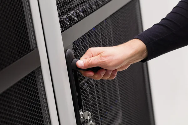 IT engineer opens door to server rack in datacenter — Stock Photo, Image