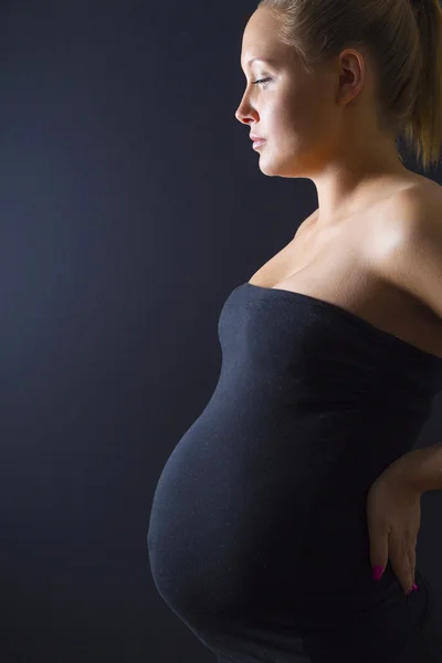 Belle femme enceinte debout avec les mains sur le dos — Photo