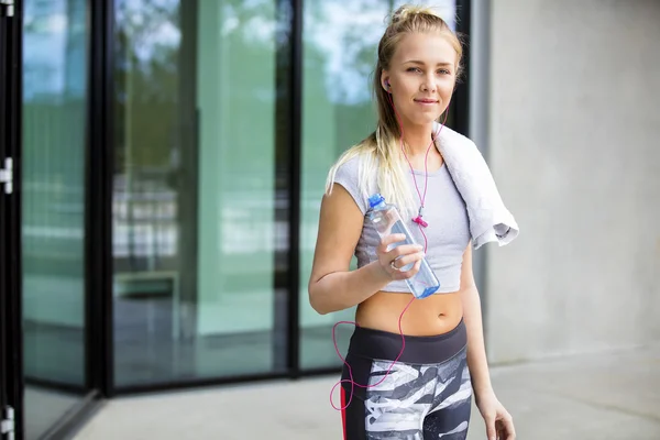 Fit Female With Water Bottle and Napkin Outside Building — стоковое фото