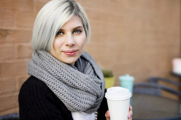 Женщина с чашкой кофе в кафе Sidewalk — стоковое фото