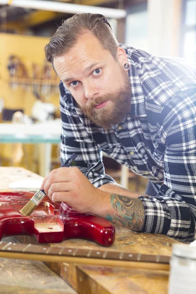 Man som arbetar på workshop med musikinstrument — Stockfoto