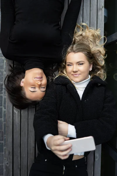 Glimlachende vrienden liggend op bank nemen selfie samen in de stad — Stockfoto