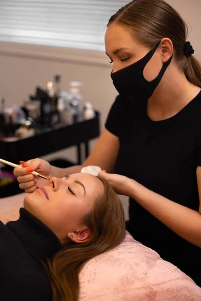 Procedimiento de extensión de pestañas con el maestro y un cliente en un salón de belleza — Foto de Stock