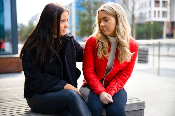 Caring Woman Comforting Her Upset and Sad Friend Outdoor