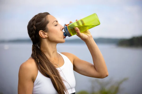 L'eau potable d'athlète femelle pendant l'entraînement extérieur — Photo