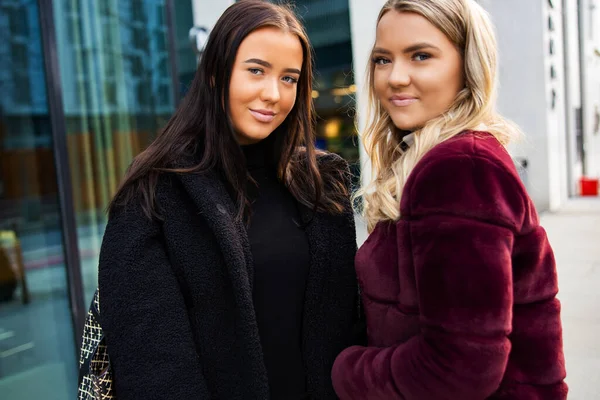 Portret van twee lachende mooie jonge vrouwen vrienden in de stad — Stockfoto