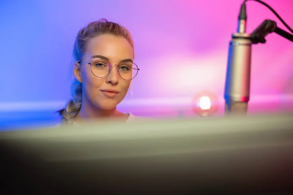 Porträt der blonden Spielerin mit Brille beim Online-Videospiel auf ihrem Computer — Stockfoto