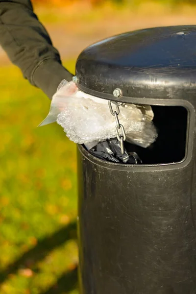 Gönüllü, parktaki çöp kutusuna plastik çöp atıyor. — Stok fotoğraf