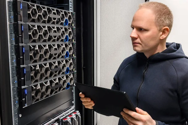 Ingénieur informatique masculin avec tablette numérique examinant les serveurs hyperconvergents — Photo