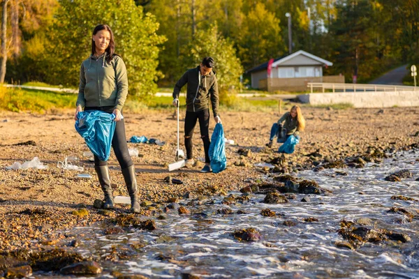 環境保全チームがビーチでゴミを拾う ロイヤリティフリーのストック写真