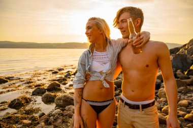 Gülümseyen İskandinav çift Gökyüzüne Karşı Sahilde Duruyor