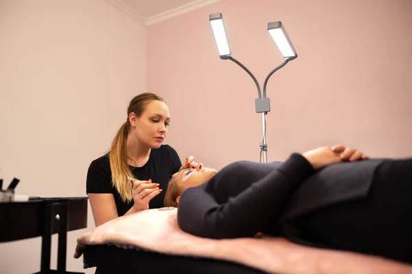 Kosmetologe verwendet Pinzette während der Behandlung der Wimpernverlängerung — Stockfoto