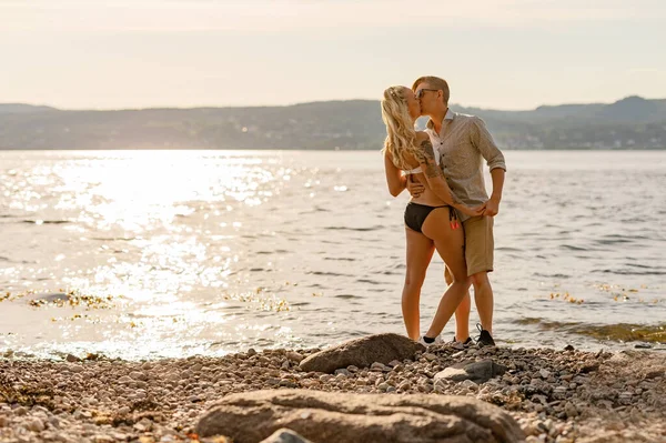 Joven y hermosa cariñosa pareja besándose en la playa — Foto de Stock