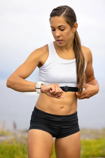 Retrato de la mujer que usa el dispositivo de reloj inteligente de fitness bajo entrenamiento — Foto de Stock