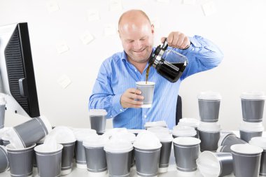 Smiling businessman drinks too much coffee clipart