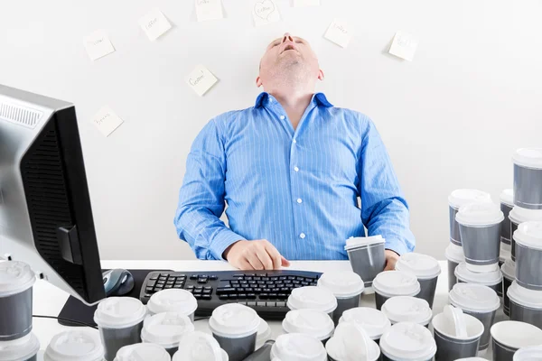 Overworked businessman drinks too much coffee — Stock Photo, Image