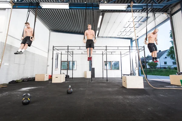 Three men exercise dips with rings — Stock Photo, Image