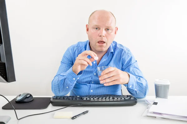 Sick and overworked office worker taking pill — Stock Photo, Image