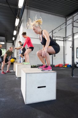 Fitness salonunda egzersiz grup trenler kutusunu atlar