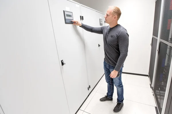 IT engineer adjusts air conditioner in datacenter — Stock Photo, Image