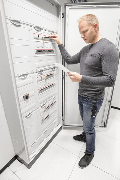 Ingenieur schaltet Zünder und liest technische Aufsätze — Stockfoto