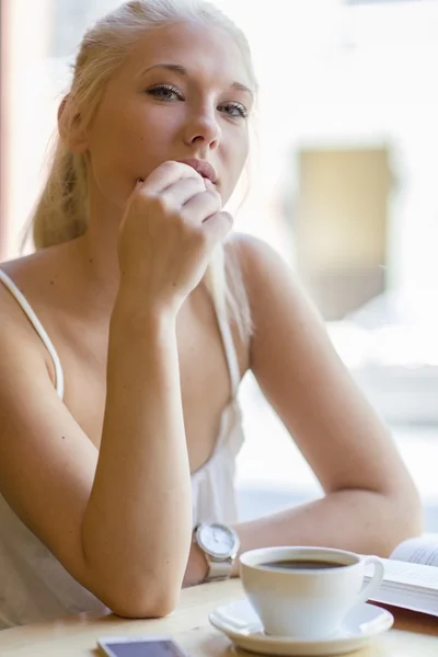 Young woman reading book at cafe — Stock Photo, Image