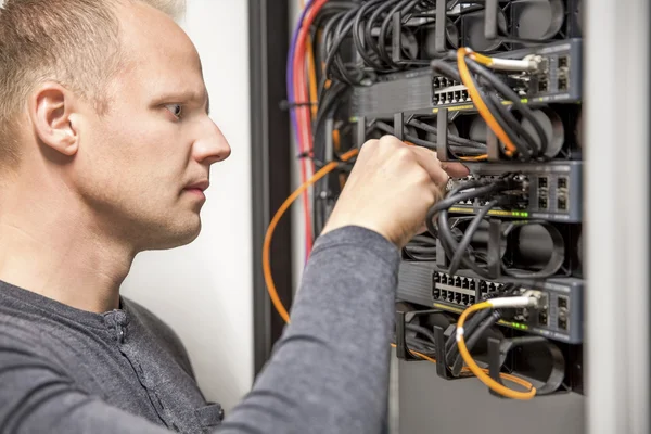 Berater verbindet Netzwerkkabel in Switch — Stockfoto