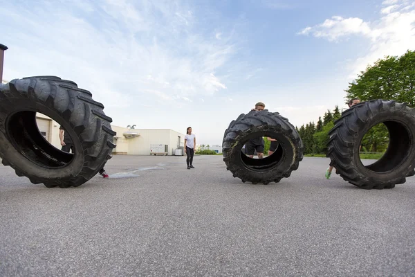 Workout team flipping heavy tires outdoor — Stock Photo, Image