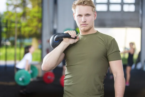 Pewny siebie człowiek z kettlebell w siłowni fitness — Zdjęcie stockowe