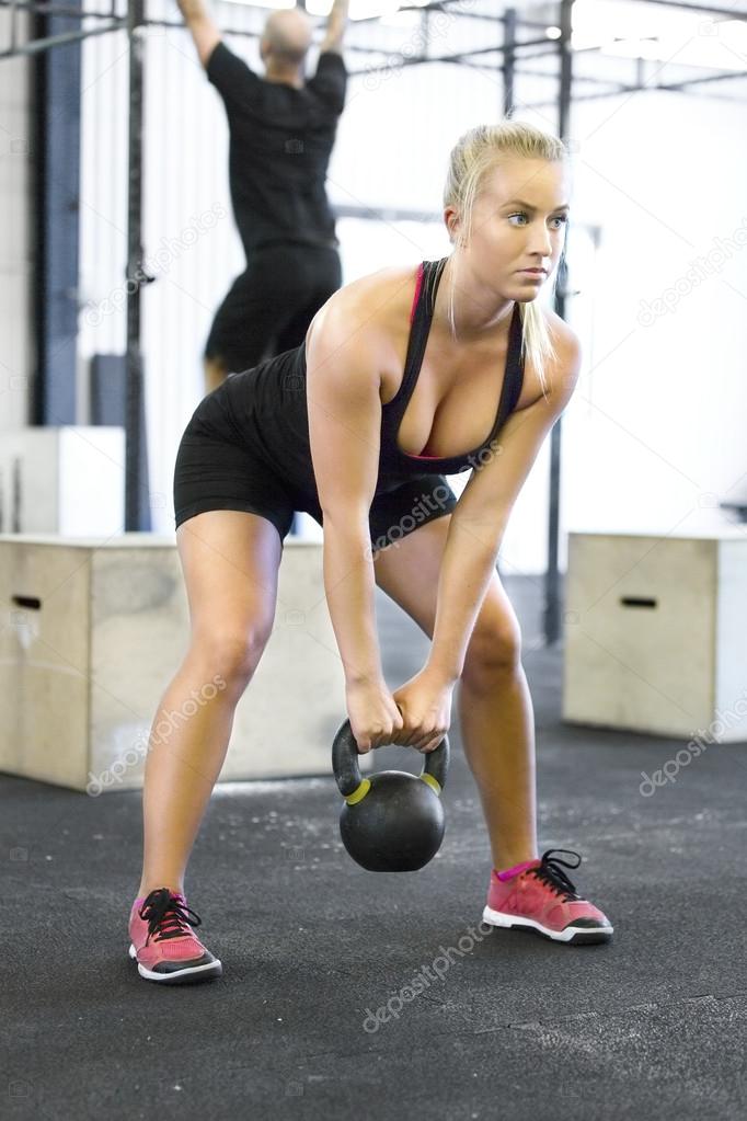 Woman with kettlebell at the fitness gym