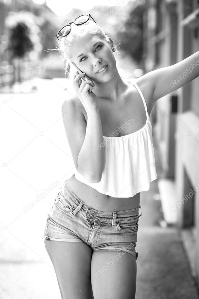 Smiling blonde teen girl talking on the phone