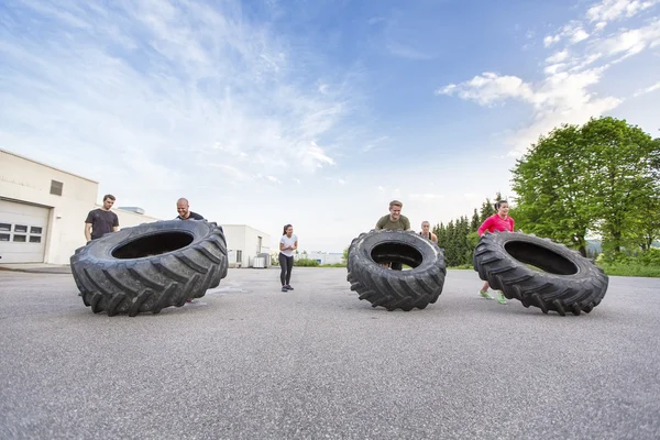 Workout team flipping heavy tires outdoor — Stock Photo, Image