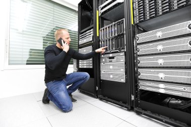 IT consultant calling support in datacenter clipart