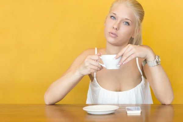Blonde woman drinks coffee at cafe — Stock Photo, Image