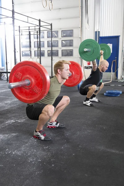Team trains squats at fitness gym center — Stock Photo, Image