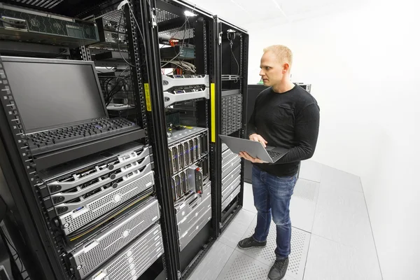 Инженер обслуживает серверы в центре обработки данных — стоковое фото