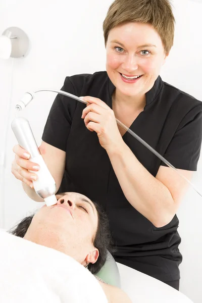 Klien mendapatkan perawatan wajah dengan tersenyum terapis — Stok Foto
