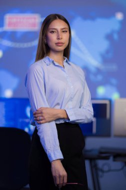 Kurumsal bir ortamda duran dengeli bir iş kadını veri teknolojisi görüntüleriyle ilgileniyor. Profesyonel büyüme, kariyer başarısı veya teknoloji güdümlü endüstri konuları için uygun.