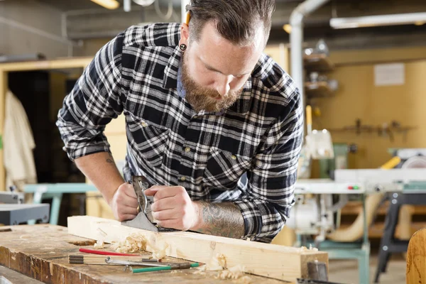 Snickare arbete med plan på trä planka i workshop — Stockfoto