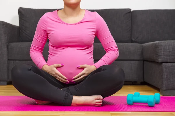 Terhes nő gyakorlása és tartja a hasát — Stock Fotó