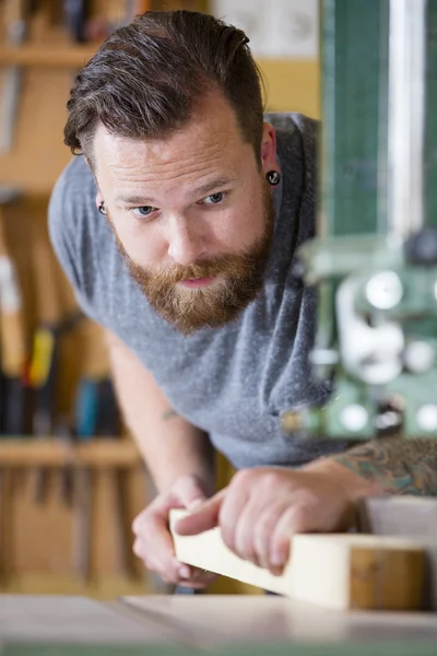 ワーク ショップで木の板を分割の鋸を使用している職人 — ストック写真