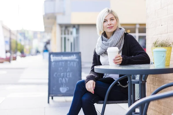 Uśmiechnięta blondynka kobieta picia kawy odkryty w kawiarni — Zdjęcie stockowe
