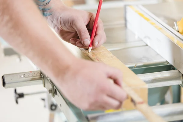 Плотник измеряет длину деревянной доски перед распиловкой — стоковое фото