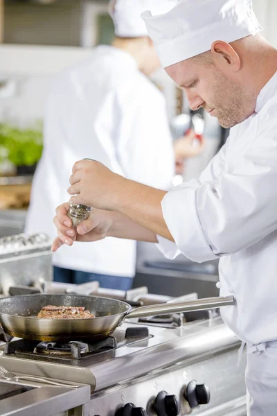 Chef prepara filete en la sartén en la cocina — Foto de Stock