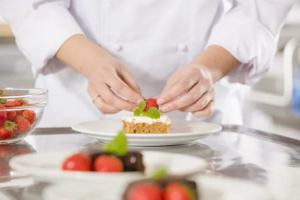 Chef dekoriert Desserttorte mit Erdbeere — Stockfoto