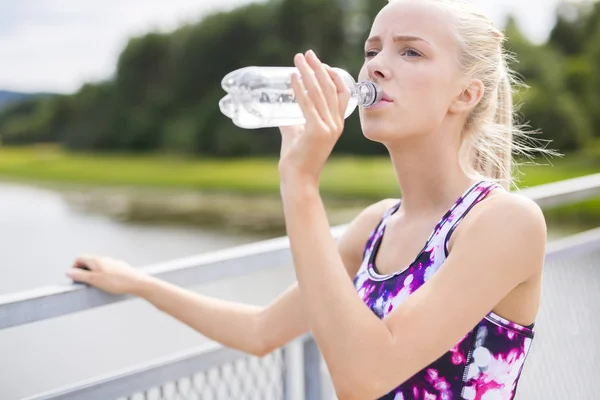 Kvinna med en paus och dryck vatten efter att ha kört — Stockfoto