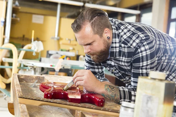 Artesanato trabalhando na oficina com uma guitarra — Fotografia de Stock