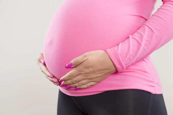 Femme enceinte tient sur son ventre gonflé — Photo